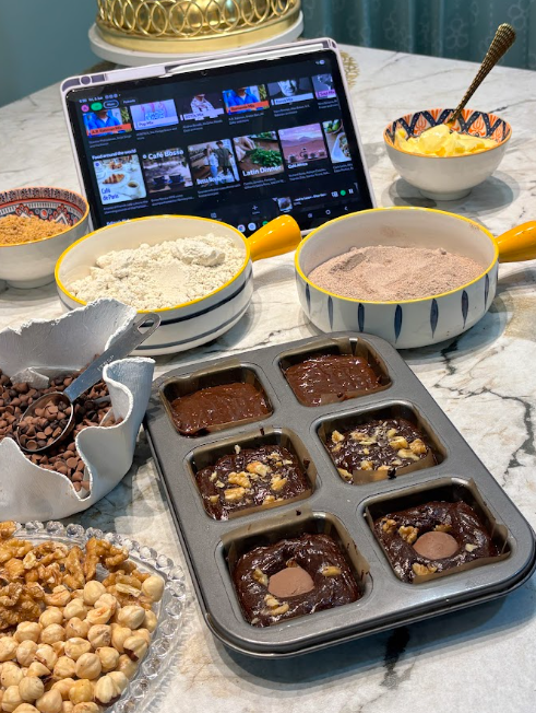 The Grain Crumbs kitchen — millet flours, walnuts and a fresh brownie tray on marble